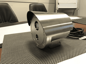 Hikvision CCTV camera on a conference table, ready for installation, showcasing advanced security surveillance technology for business premises.